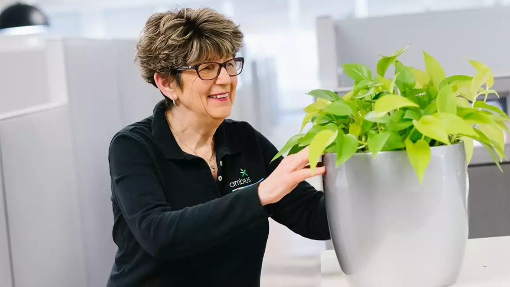 ambius-colleague-image-woman-with big-plant-pot-us.webp
